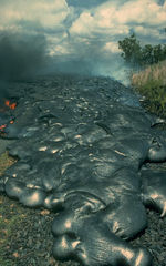 Toes of a pāhoehoe advance across a road in Kalapana on the east rift zone of Kīlauea Volcano in Hawai‘i.