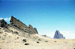 Shiprock, New Mexico a volcanic neck in the distance, with radiating dike on its south side. Photo credit: USGS Digital Data Series