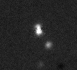 An image of Pluto and Charon taken with a 61" telescope; note the difficulty in resolution despite telescope size. This small size is one of the reasons Pluto's planetary status is debated.