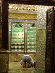 A Shia man in prostration, performing morning prayers inside an Imamzadeh.
