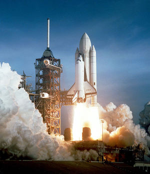 The Space Shuttle Columbia seconds after engine ignition, 1981 (NASA). For the first two missions only, the external fuel tank spray-on foam insulation was painted white. Subsequent missions have had an unpainted tank, thus exposing the orange colored foam insulation. This resulted in a weight saving of over 450 kg (1000 lbs) allowing equivalently increased payload capacity to orbit.